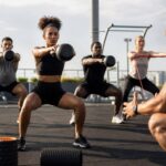 Atletas realizando treino funcional ao ar livre focados em técnica e recuperação